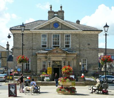 Historic stone building with people and dogs in front.