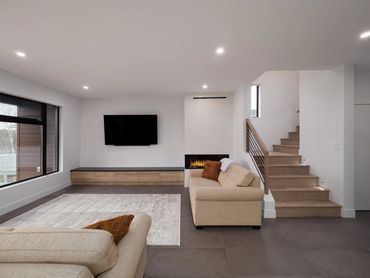 Home builder Prince George
Coner fireplace with concrete panel wall
Wood flooring on stairs