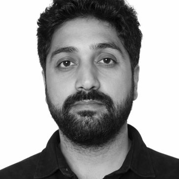 Black and white portrait of a man with beard and curly hair.