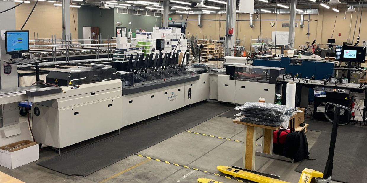 Large industrial printing and packaging machine in a warehouse.