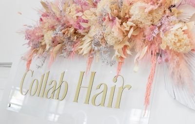 Sign reading 'Collab Hair' with floral decoration.