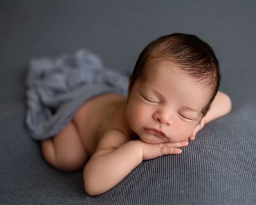 Newborn boy in blue tones during studio newborn session