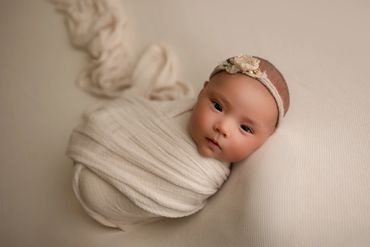 one month old newborn wrapped in cream wrap during session with best newborn photographer on corona.