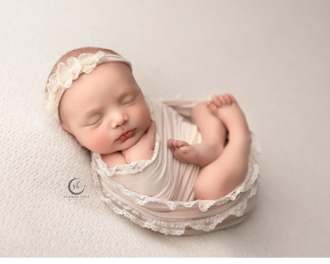 Newborn Photoshoot of little girl wrapped in dainty fabric during her session at Corona photography.