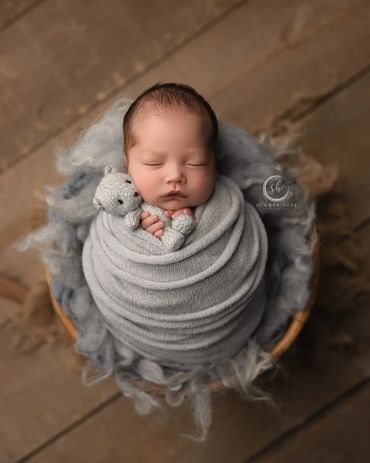 Baby boy with bear prop snuggled up at his newborn studio session at Eastvale photography studio.