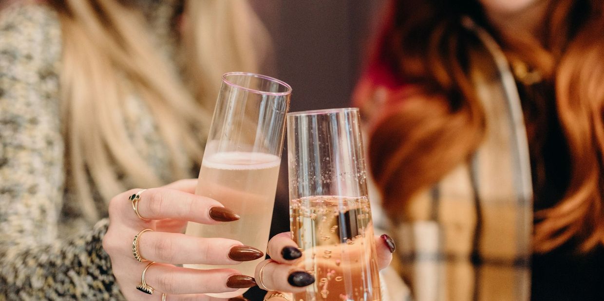 two best friends have a glass of Champagne celebrating their new hair extensions