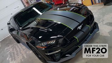 Matte black full length stripes with gloss green outline on late model black Mustang.