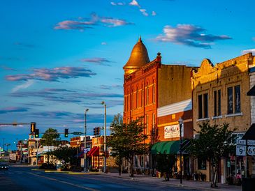 Historic downtown street with colorful buildings under a bright blue sky.
