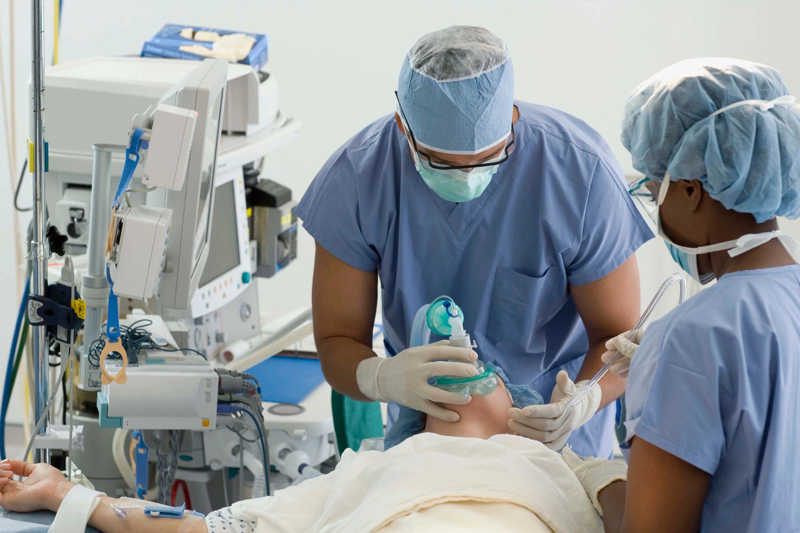 Picture of anesthesiologist preparing a patient to begin a surgical procedure.
