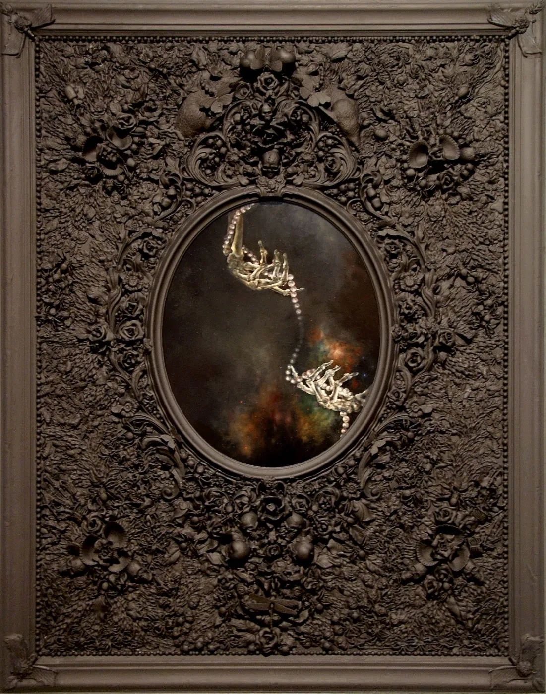 Oil painting. Large, Gothic black frame. Oval insert with skeletal hands reaching to each other. 