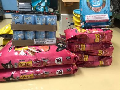 Bags of dry cat food and pallets of canned cat food donated for food pantry and community cats.