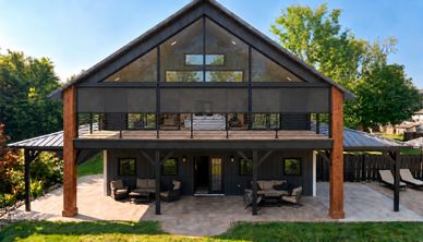 Modern two-story house with outdoor seating.