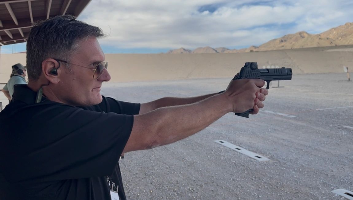 Wayne using a pistol