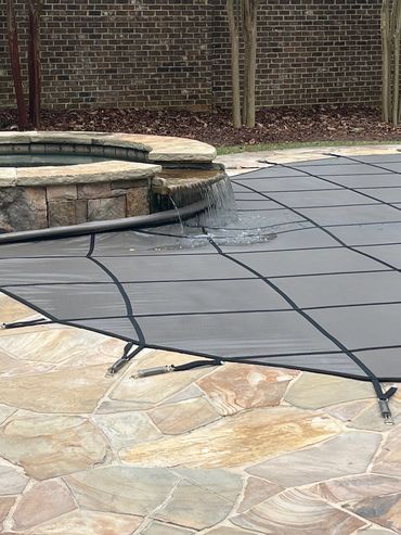 spillover from raised spa flowing onto a pool cover