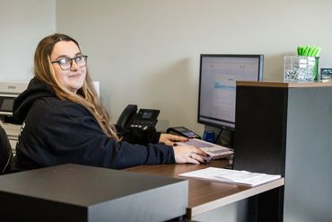 Expert Auto Service office staff processing DMV registration documents and preparing customer record