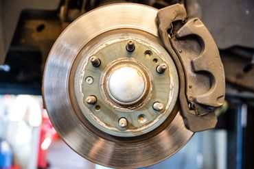 Close-up image of a brake rotor and caliper during a brake inspection at Expert Auto Service in Meri