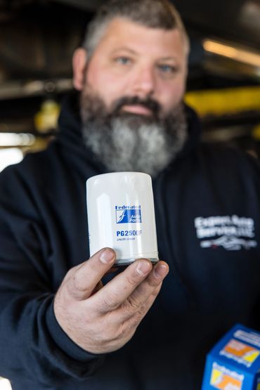 Owner Steve Oakes at Expert Auto Service holding a replacement part used during brake and safety rep