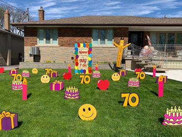 Birthday signs on a lawn with assorted lawn ornaments and a Happy Birthday air dancer