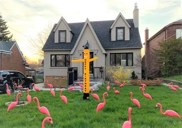 A Happy Birthday wind dancer on a lawn display with plastic pink flamingo rentals