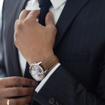 A man adjusting his tie, ensuring it is properly positioned