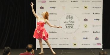 Leanne Zaccar inspirational speaker at Mindful Living Expo storytelling and dancing on stage