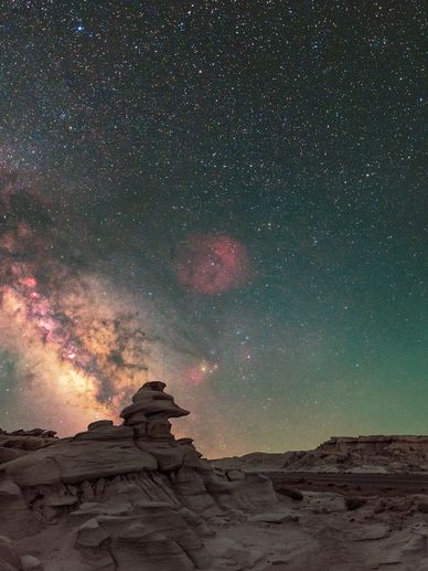 Starry night sky over rock formations