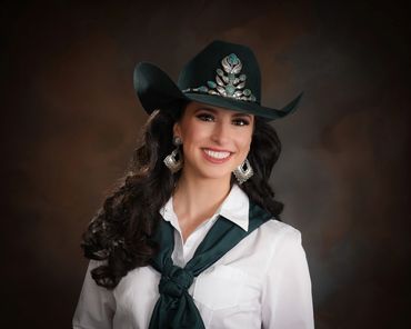 Smiling woman in a decorated cowboy hat and white shirt.