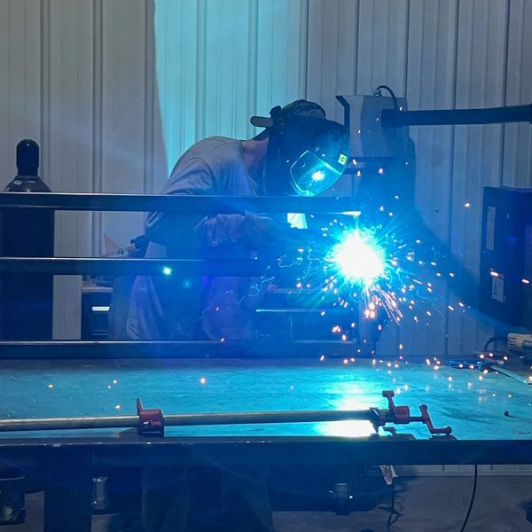 Nate Bedwell cutting a metal sign