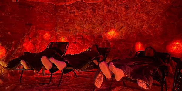 Feet in white socks resting in the Salt Cave, showcasing the required footwear for the experience.