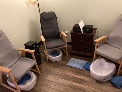 Three ionic foot bath detox stations with a highback chair and a basin for your feet.