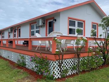 Outside of a three-plex with a large deck with seating options.