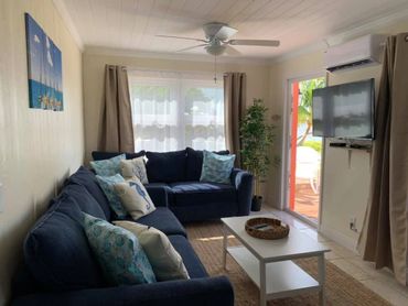 Living room area with two large couches, a coffee table, and a large flatscreen TV.