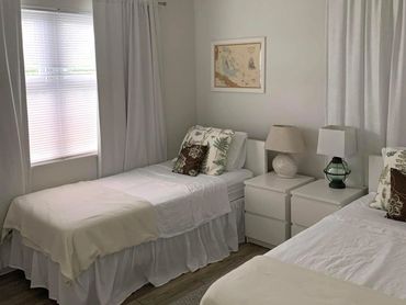 A bedroom with two twin beds, nightstands, and reading lights.