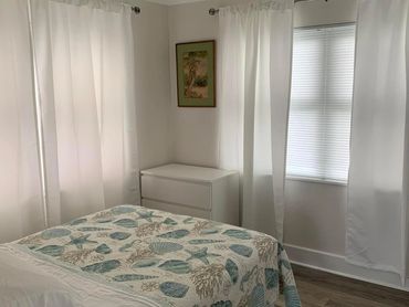 Bright bedroom with neatly made bed.