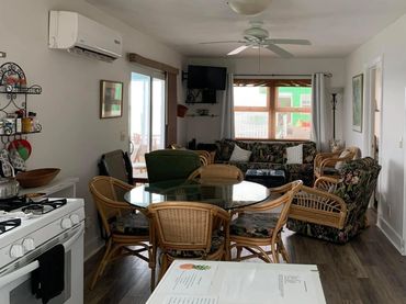 Living room area with couch, chairs and dining table.