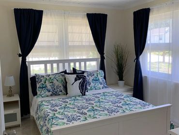 Queen bedroom with windows on two sides.