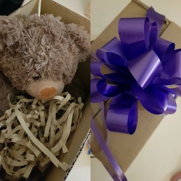 This shows a teddy, a box, soft paper and a bow