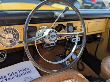 Interior of a vintage car with a classic steering wheel and dashboard.