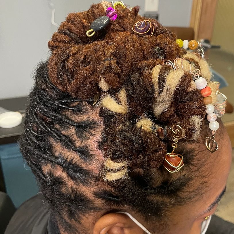 Intricately styled dreadlocks with decorative beads and wraps.