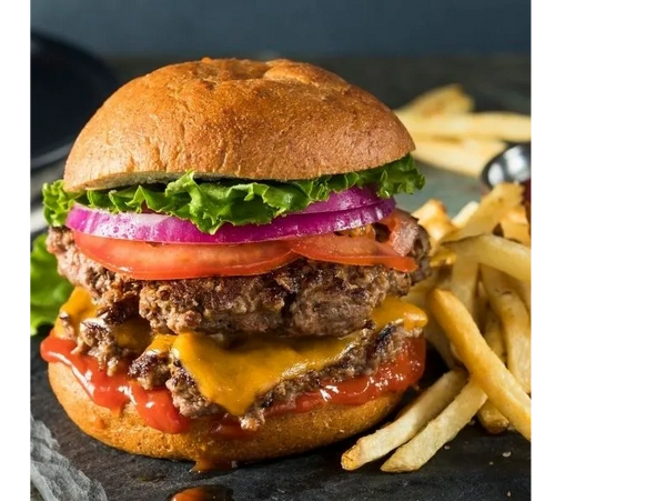Juicy double cheeseburger with lettuce, tomato, onion, and fries on the side.