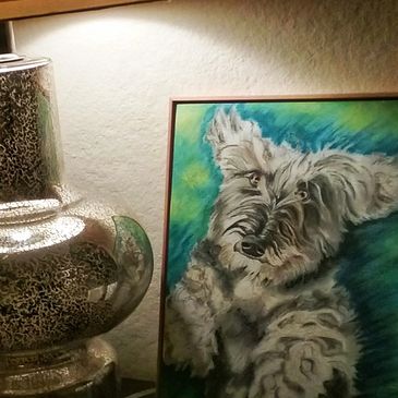 cozy table arrangement with soft glow of designer lamp and portrait of Wire-haired Dachshund sittinge