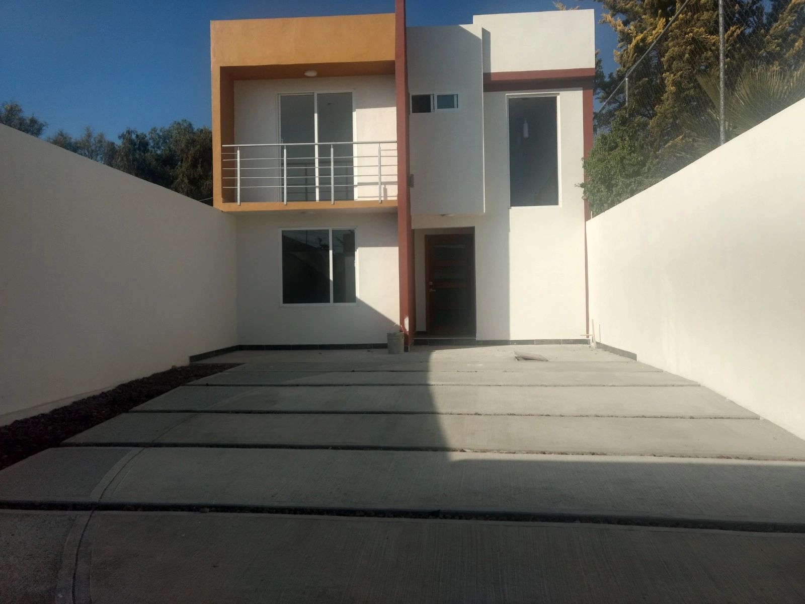 Casa moderna de dos pisos con garaje amplio y balcón.