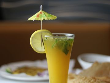 A drink with a slice of lemon and an umbrella
