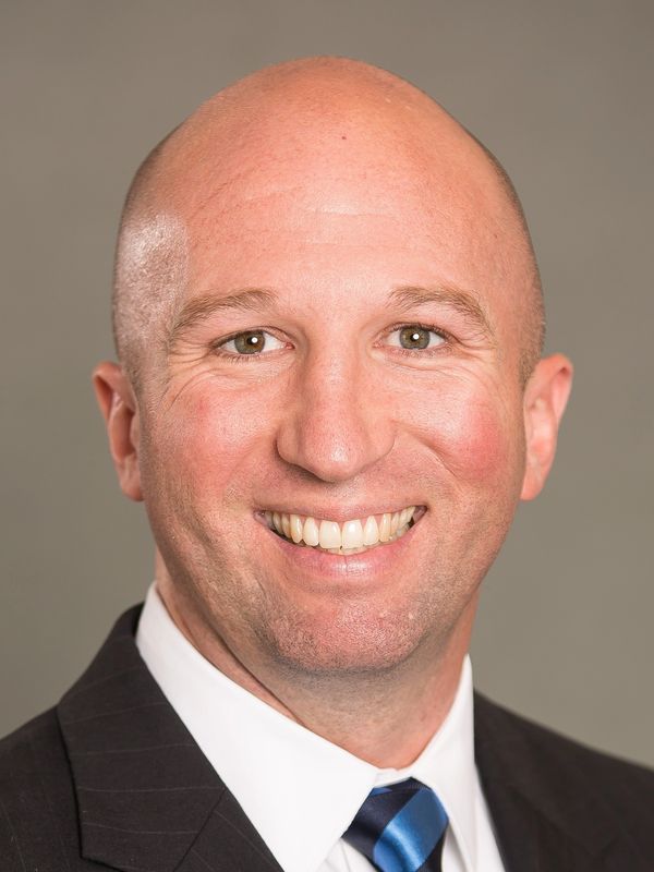 Smiling bald man in a suit and tie.