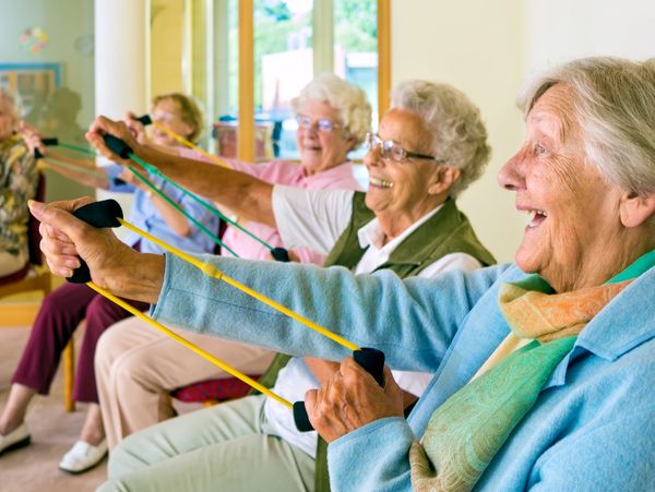 Large group of happy enthusiastic elderly women exercising.