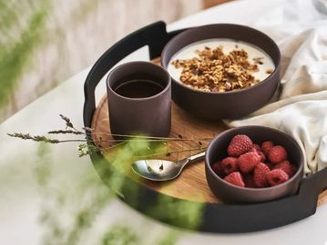 Breakfast tray with delicious offerings placed on a bed.
