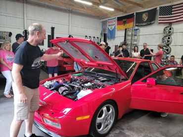 The engine bay is being displayed from the Red 1986 Porsche 944 Turbo