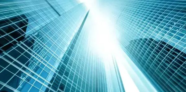 Sunlight reflecting off modern glass skyscrapers in a city.