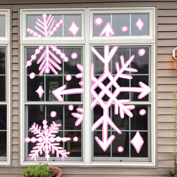 Winter-themed pink snowflake decorations on a window.