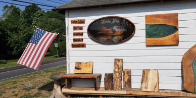 Artisan woodwork shop with rustic wooden furniture and an American flag.